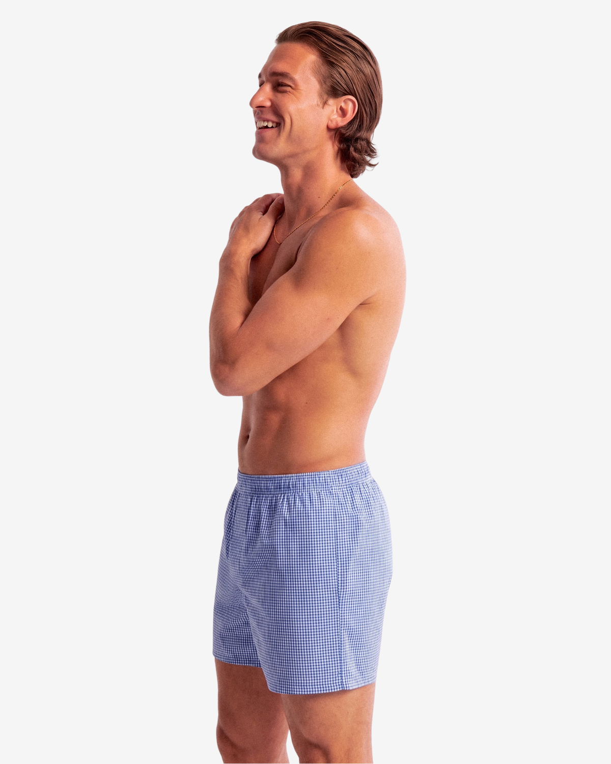 Smiling model wearing Son of John Marine Gingham boxer shorts, side view